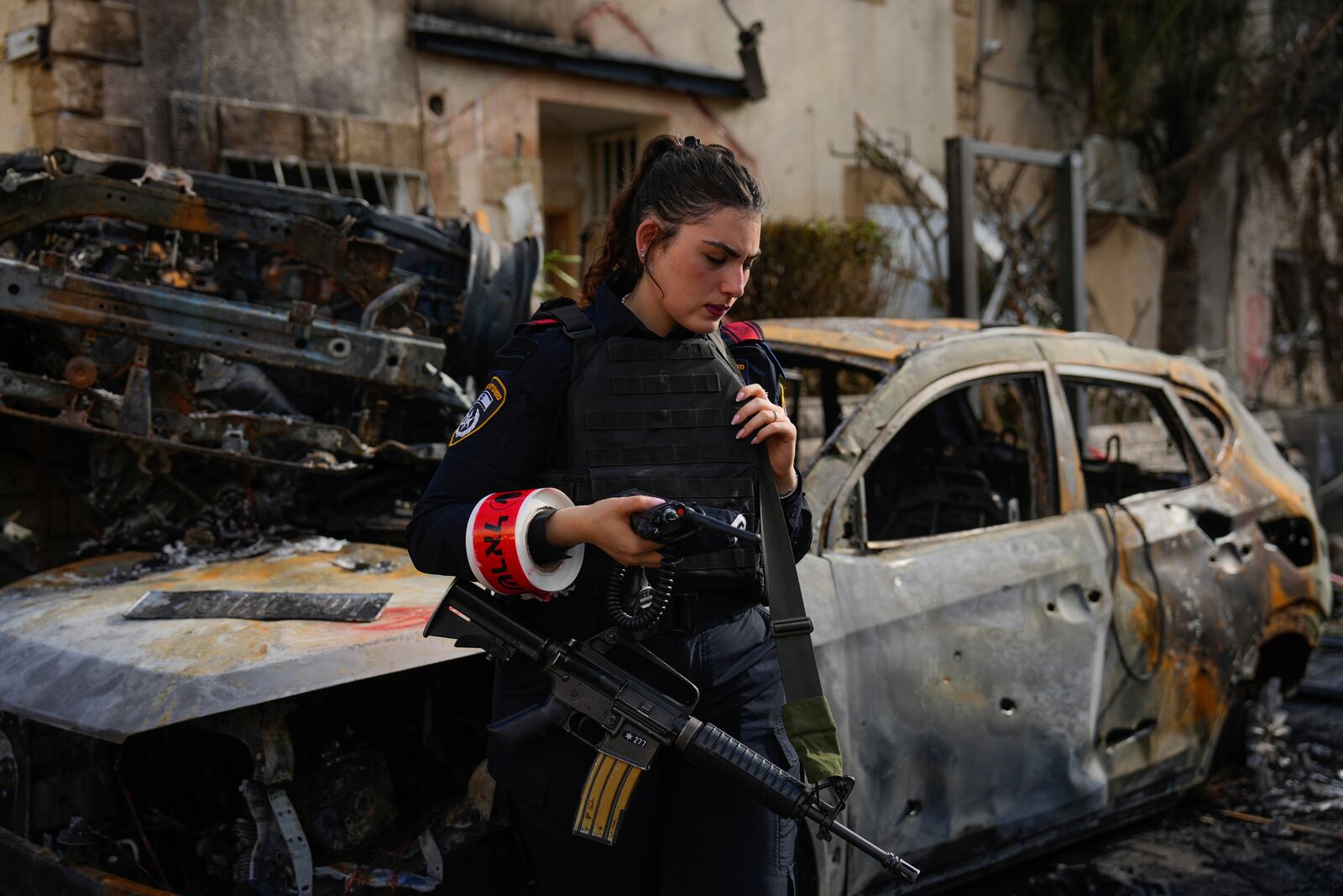 An Israeli police officer examines the site hit by a rocket fired from Lebanon, in Kiryat Bialik, northern Israel, on Sunday, Sept. 22, 2024. (AP Photo//Ariel Schalit)