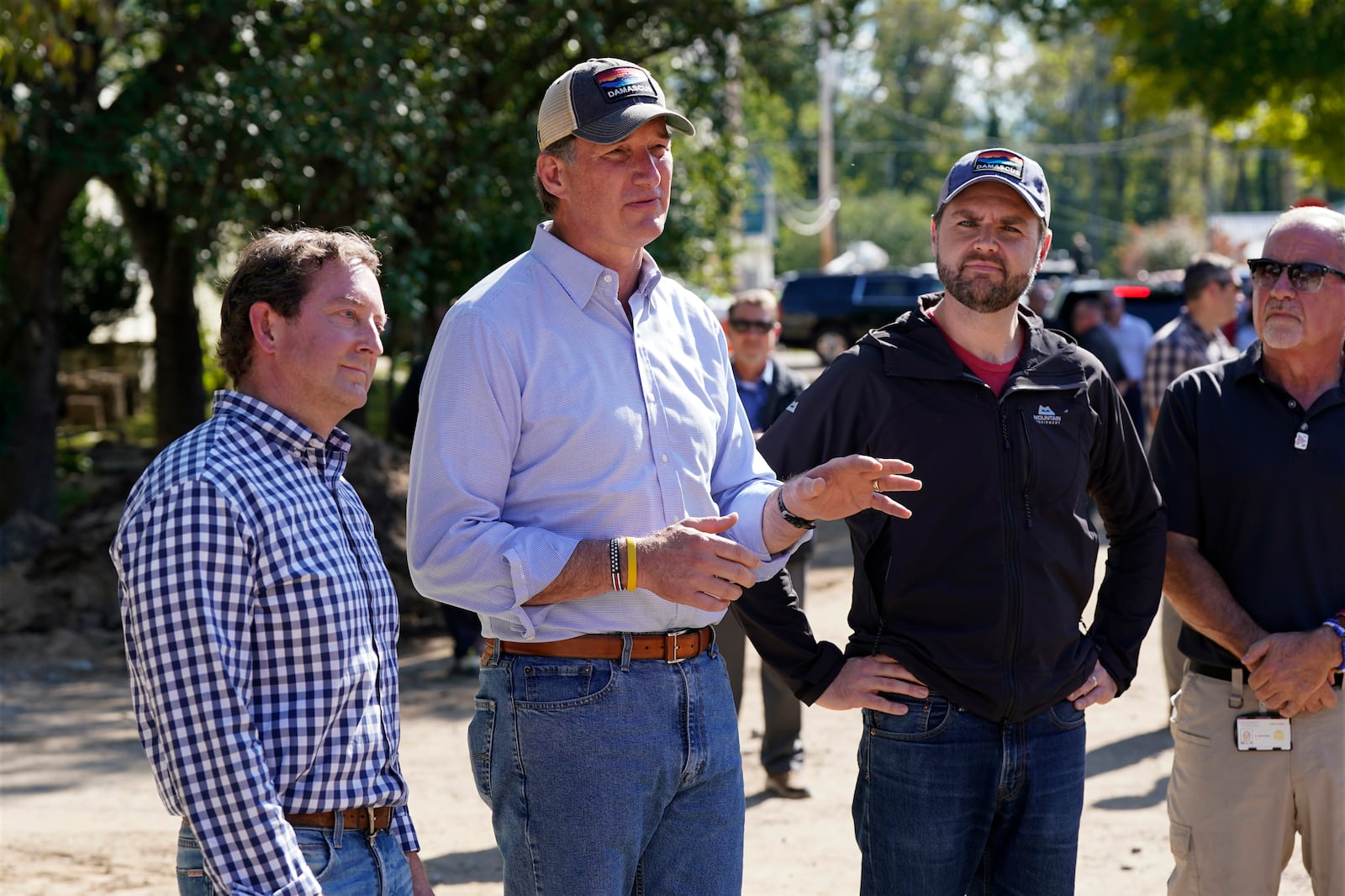 Republican vice presidential nominee Sen. JD Vance, R-Ohio, listens to Virginia Gov. Glenn Youngkin as he visits areas impacted by Hurricane Helene in Damascus, Va., Thursday Oct. 3, 2024. At left is state Sen. Todd Pillion. (AP Photo/Steve Helber)