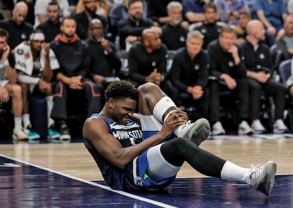 Minnesota Timberwolves guard Anthony Edwards (5) grabs his leg on the court during the first half of Game 2 of an NBA basketball second-round playoff series against the Golden State Warriors, Thursday, May 8, 2025, in Minneapolis. (Carlos Avila Gonzalez/San Francisco Chronicle via AP)