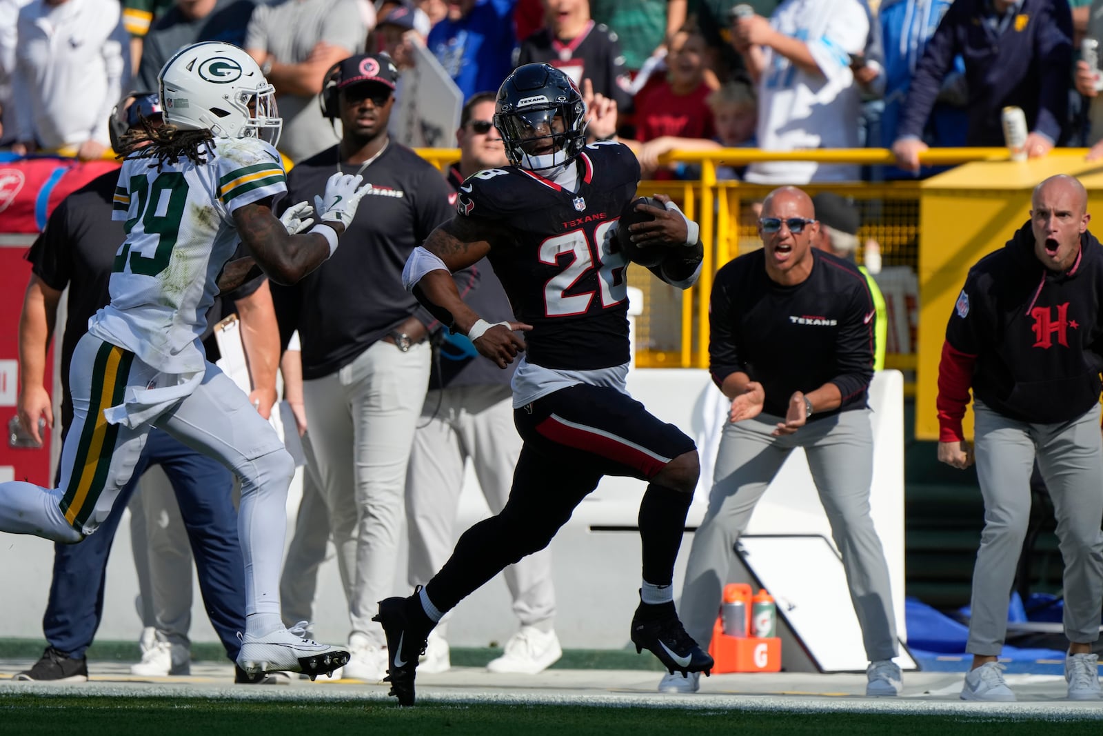 Houston Texans running back Joe Mixon (28) runs past Green Bay Packers safety Xavier McKinney (29) for a first down during the first half of an NFL football game, Sunday, Oct. 20, 2024, in Green Bay, Wis. (AP Photo/Morry Gash)