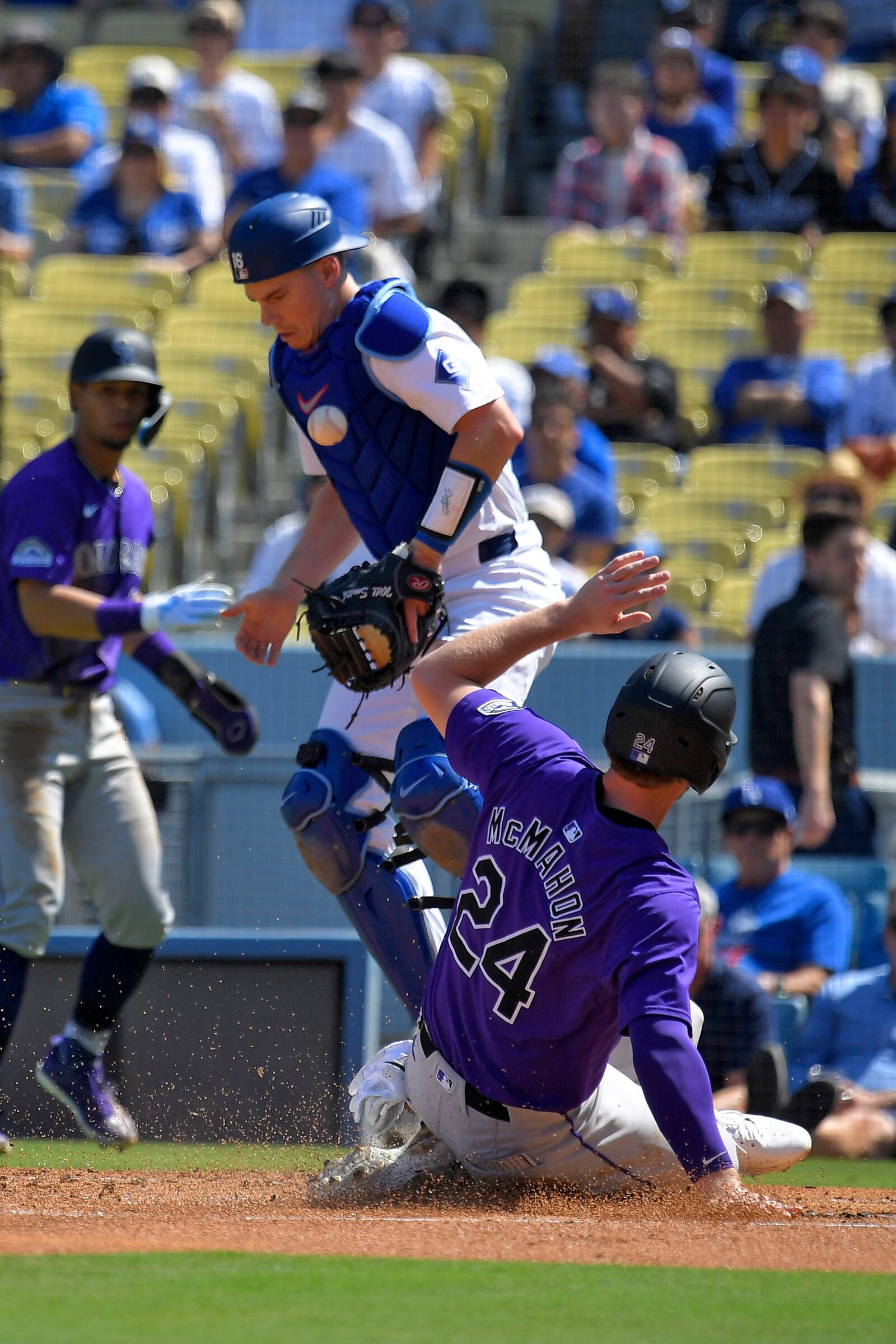 Colorado Rockies' Ryan McMahon, right, scores on a single by Brendan Rodgers as Los Angeles Dodgers catcher Will Smith takes a late throw during the first inning of a baseball game, Sunday, Sept. 22, 2024, in Los Angeles. (AP Photo/Mark J. Terrill)