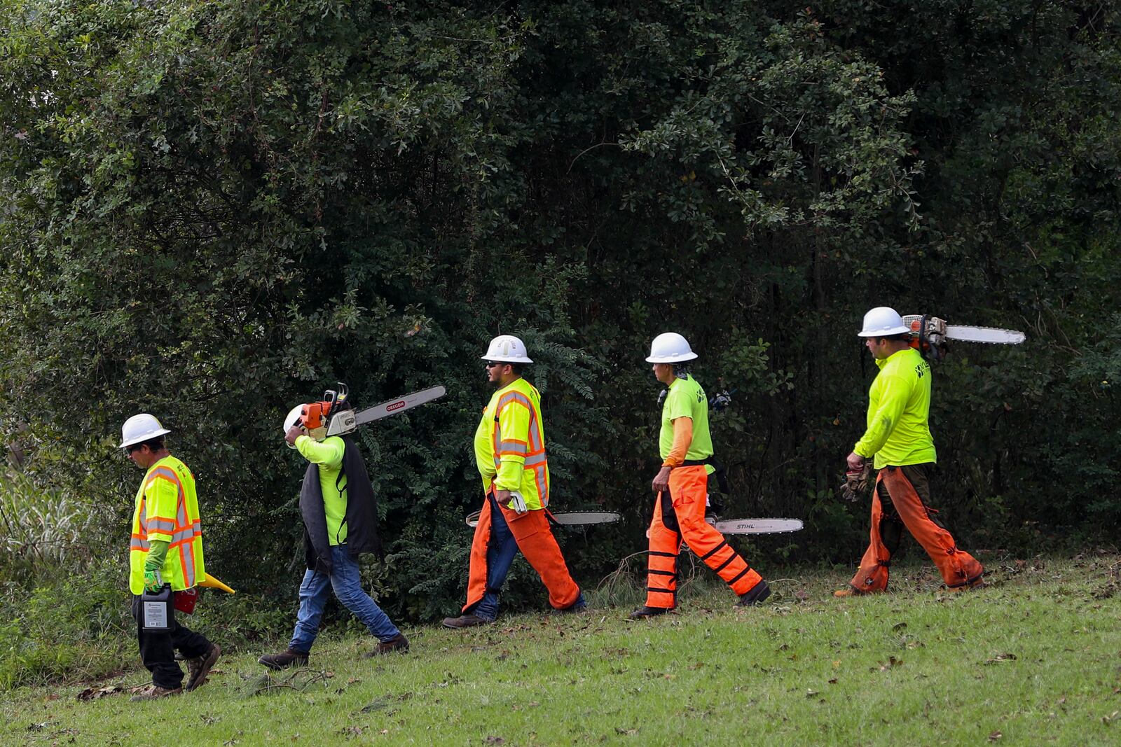 Crew members from Xylem Tree Experts walk to a staging area at Langley Pond Park in the aftermath of Hurricane Helene Sunday, Sept. 29, 2024, in Aiken, S.C. (AP Photo/Artie Walker Jr.)