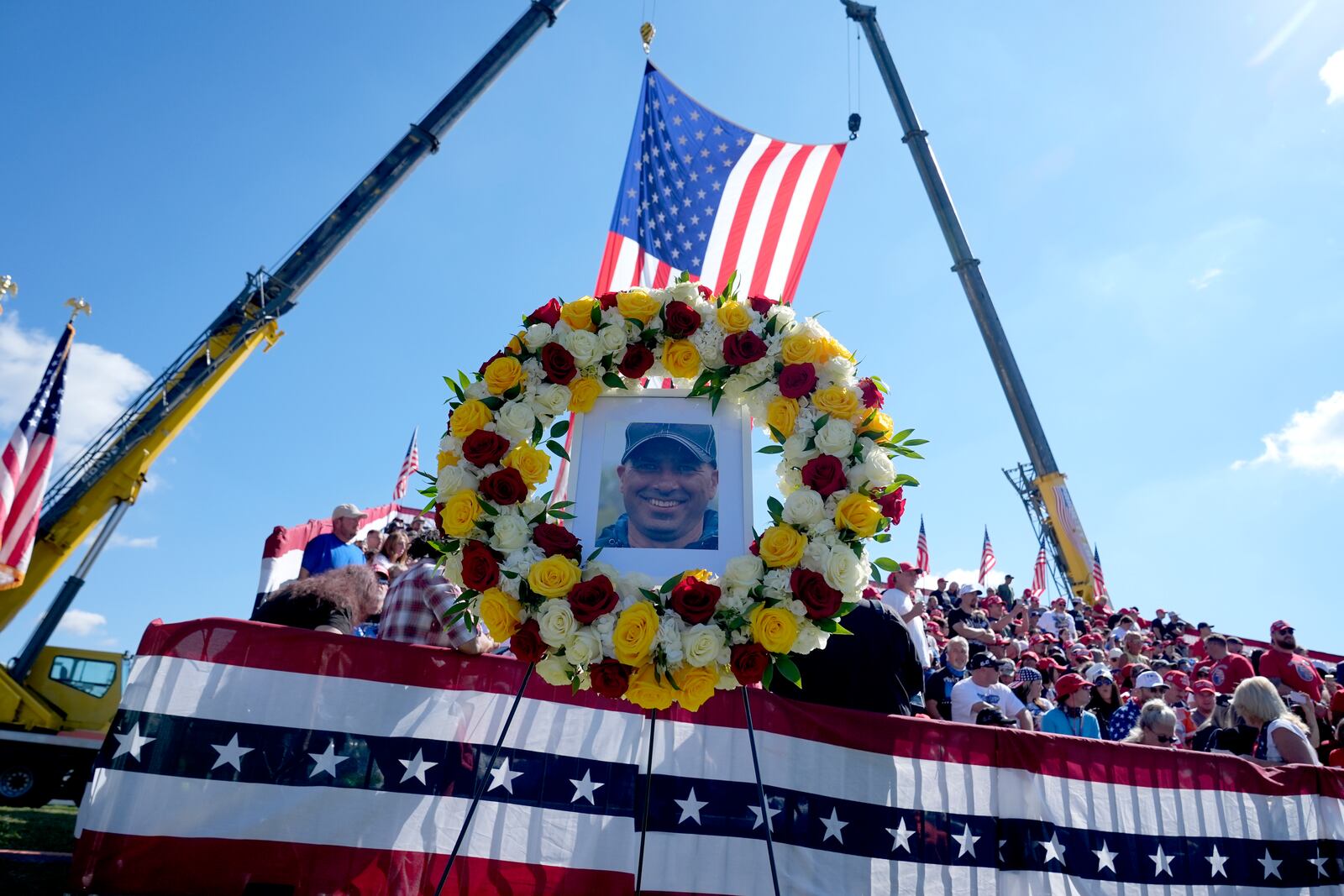 A memorial for firefighter Corey Comperatore, who died as he shielded family members from gunfire, is seen in the bleachers as attendees arrive before Republican presidential nominee former President Donald Trump speaks at the Butler Farm Show, the site where a gunman tried to assassinate Trump in July, Saturday, Oct. 5, 2024, in Butler, Pa. (AP Photo/Alex Brandon)