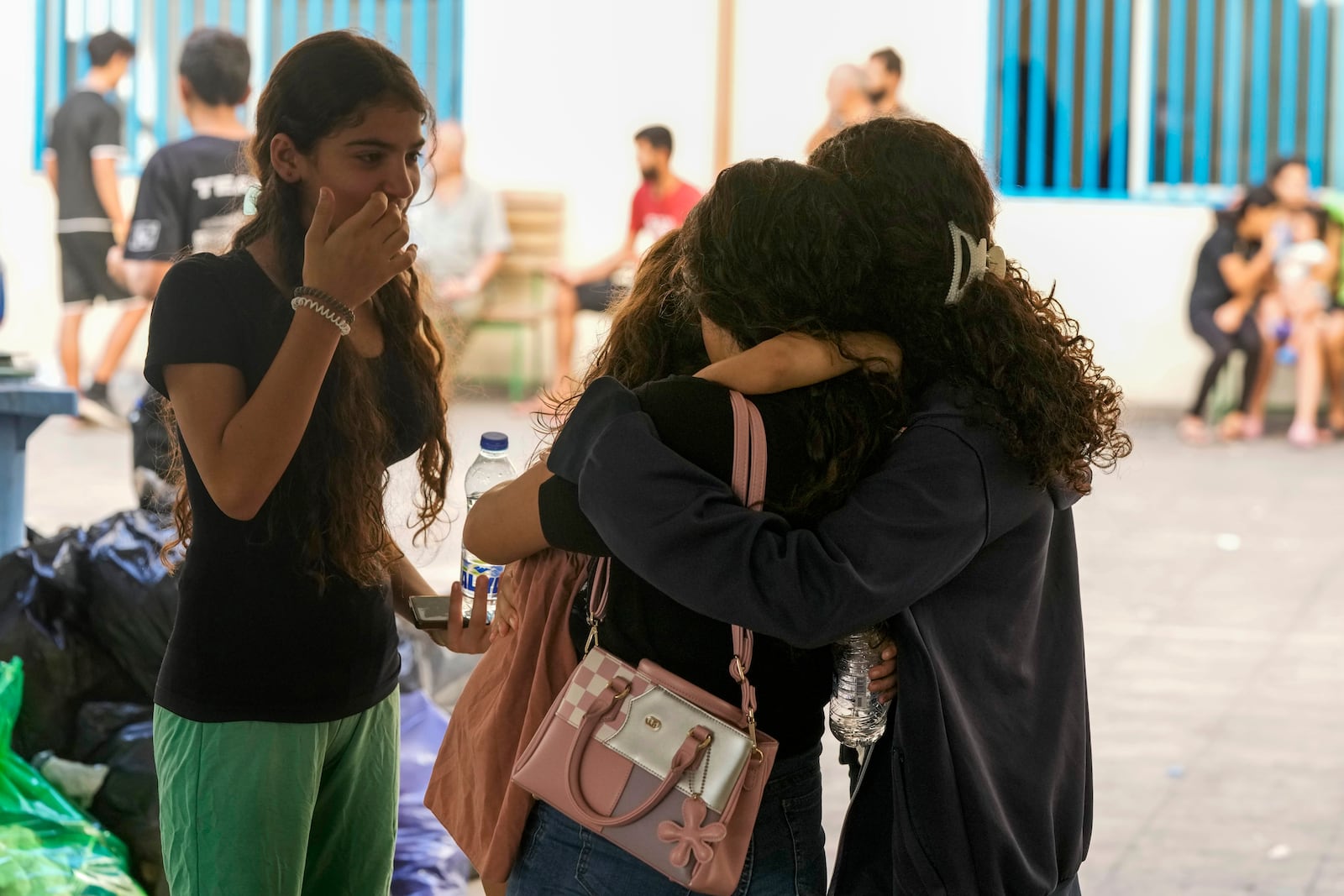 Displaced youth hug as they take shelter at a school in Beirut, after fleeing the Israeli airstrikes in the south with their families, Thursday, Sept. 26, 2024. (AP Photo/Bilal Hussein)