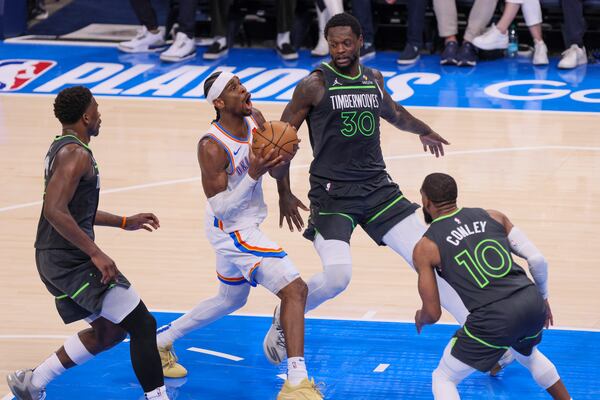 Oklahoma City Thunder guard Shai Gilgeous-Alexander, center, drives to the basket against Minnesota Timberwolves guard Anthony Edwards, left, forward Julius Randle (30) and guard Mike Conley (10) during the first half of Game 1 of an NBA basketball Western Conference Finals playoff series Tuesday, May 20, 2025, in Oklahoma City. (AP Photo/Nate Billings)