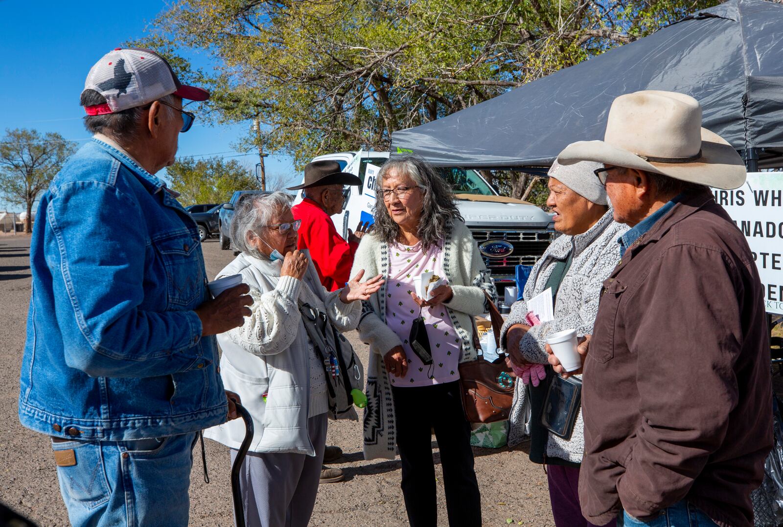 Pauline Larry, second from left, discuss community issues with fellow voters outside a polling station on the Navajo Nation in Ganado, Ariz., on Election Day, Tuesday, Nov. 5, 2024. (AP Photo/Andres Leighton)