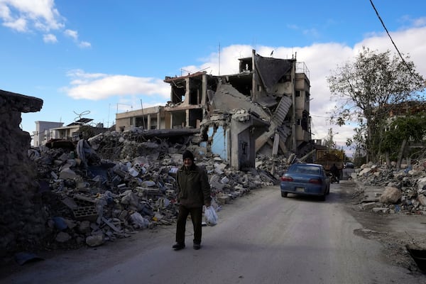 An elderly man walks near damaged buildings in Baalbek, eastern Lebanon, Thursday, Nov. 28, 2024. (AP Photo/Hassan Ammar)