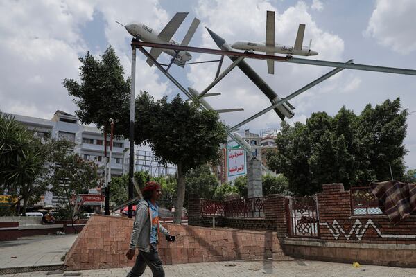 A Yemeni man walks past a monument featuring mock rockets in Sanaa, Yemen, Monday, May 5, 2025. (AP Photo/Osamah Abdulrahman)