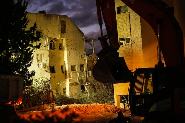 An excavator works at the site where a day before a residential building was hit by a rocket fired from Lebanon, in Haifa, Israel, Monday, Nov. 25, 2024. (AP Photo/Francisco Seco)