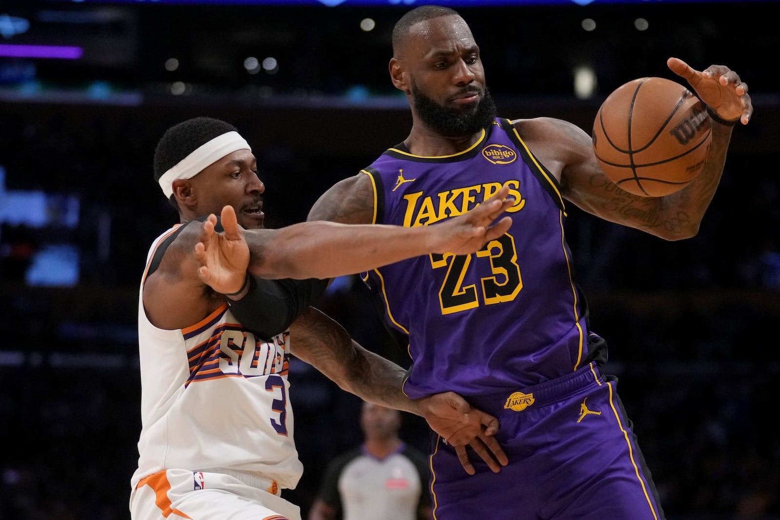 Los Angeles Lakers forward LeBron James (23) and Phoenix Suns guard Bradley Beal (3) fight for a loose ball during the second half of an NBA basketball game in Los Angeles, Friday, Oct. 25, 2024. (AP Photo/Eric Thayer)