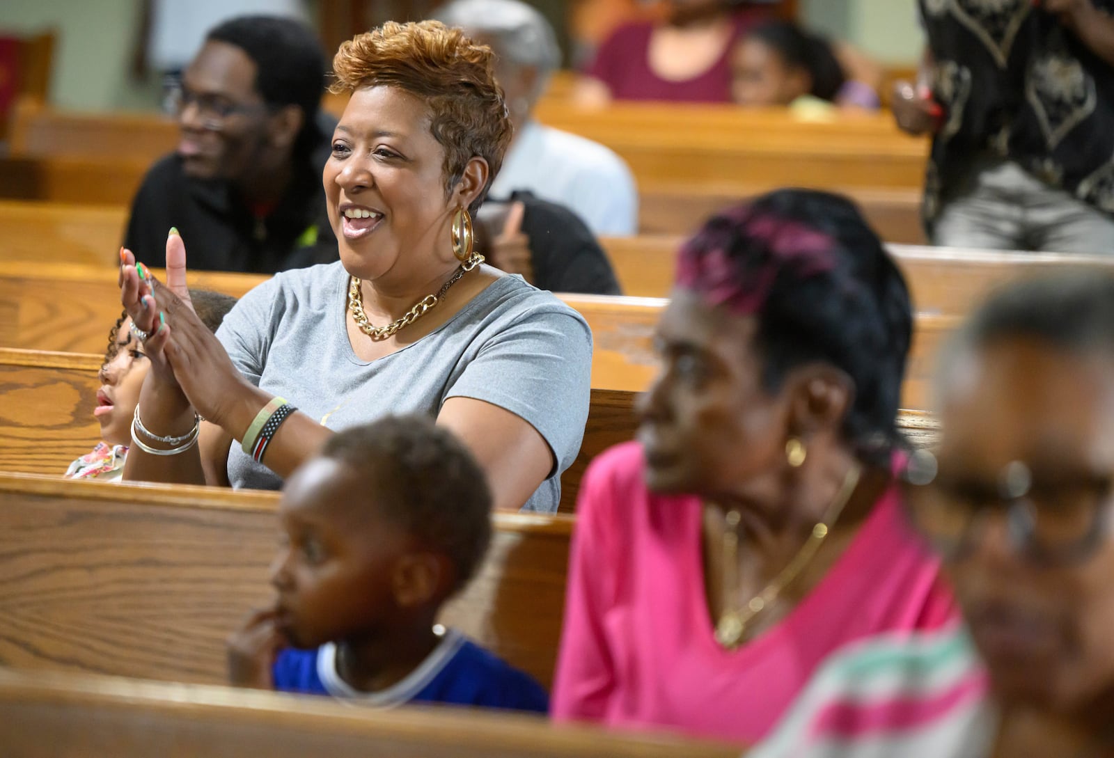 Loreasa Minor, of Turner Station, Md., seated with family friend Zoey Rogers, left, 5, claps during a service at Mt. Olive Baptist Church, Sunday, Aug. 18, 2024, in Turner Station. Turner Station is located near the former site of the Francis Scott Key Bridge, which collapsed in March. (AP Photo/Steve Ruark)