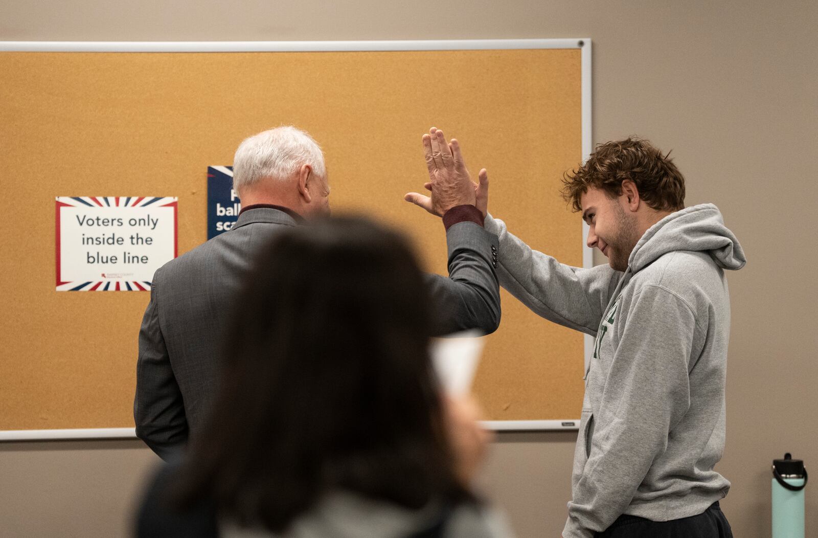 Minnesota Governor and Vice Presidential candidate Tim Walz high-fives his son, Gus Walz, a first time voter, as they cast their ballots during early voting at Ramsey County Elections in St. Paul, Minn., on Wednesday, October 23, 2024. (Renée Jones Schneider/Star Tribune via AP)