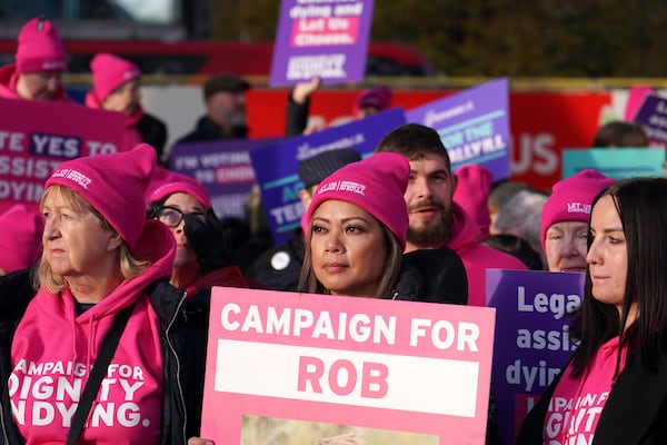 People show placards during a protest in front of Parliament in London, Friday, Nov. 29, 2024 as British lawmakers started a historic debate on a proposed to help terminally ill adults end their lives in England and Wales.(AP Photo/Alberto Pezzali)