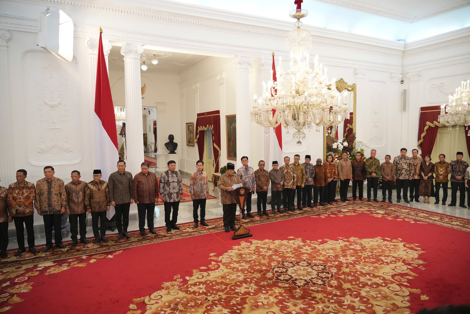 Newly appointed cabinet ministers stand behind Indonesia's new President Prabowo Subianto, center, as he announces his cabinet lineup at Merdeka Palace in Jakarta, Indonesia, Sunday, Oct. 20, 2024. (AP Photo/Achmad Ibrahim)