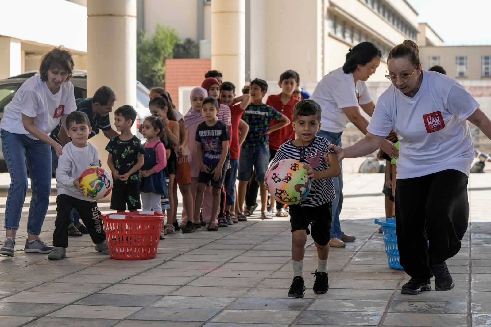 Volunteers of the Russian Cultural Center entertain displaced children at a school in Beirut, Lebanon, Thursday, Oct. 3, 2024, after fleeing the Israeli airstrikes in the south. (AP Photo/Bilal Hussein)