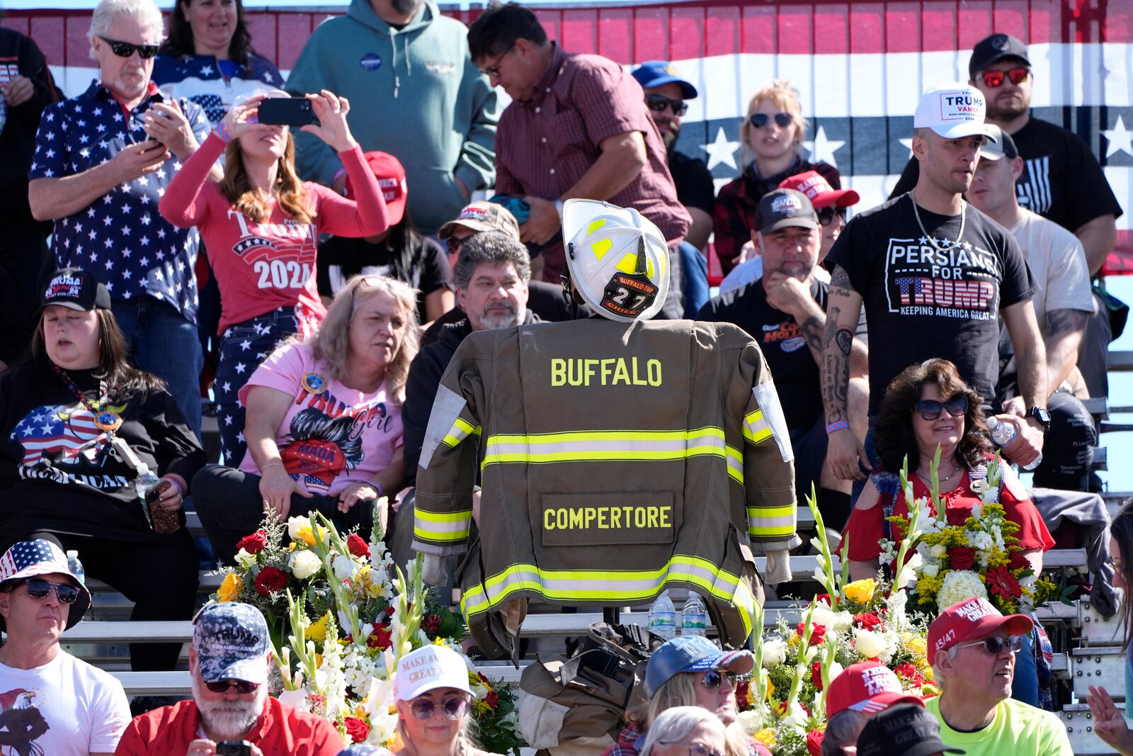 A memorial for firefighter Corey Comperatore, who died as he shielded family members from gunfire, is seen in the bleachers as attendees arrive before Republican presidential nominee former President Donald Trump speaks at the Butler Farm Show, the site where a gunman tried to assassinate Trump in July, Saturday, Oct. 5, 2024, in Butler, Pa. (AP Photo/Alex Brandon)