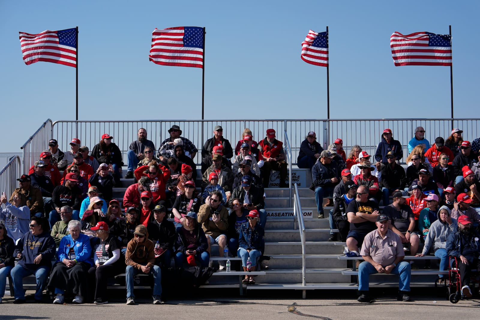 People wait for Republican presidential nominee former President Donald Trump to speak during a campaign rally at Dodge County Airport, Sunday, Oct. 6, 2024, in Juneau, Wis. (AP Photo/Julia Demaree Nikhinson)