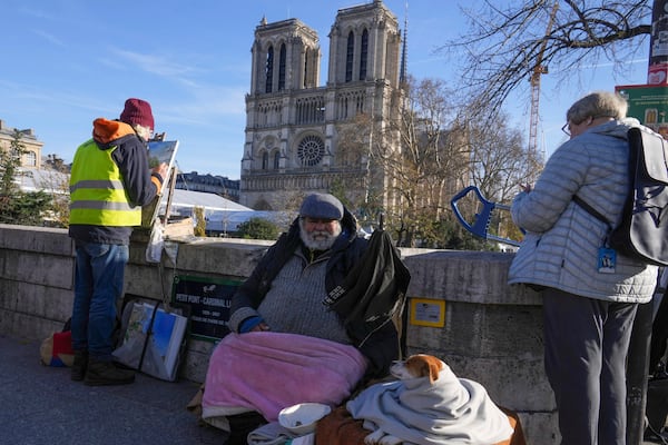 People gather as French President Emmanuel Macron visits the renovated Notre Dame Cathedral Friday, Nov. 29, 2024 in Paris. (AP Photo/Michel Euler)