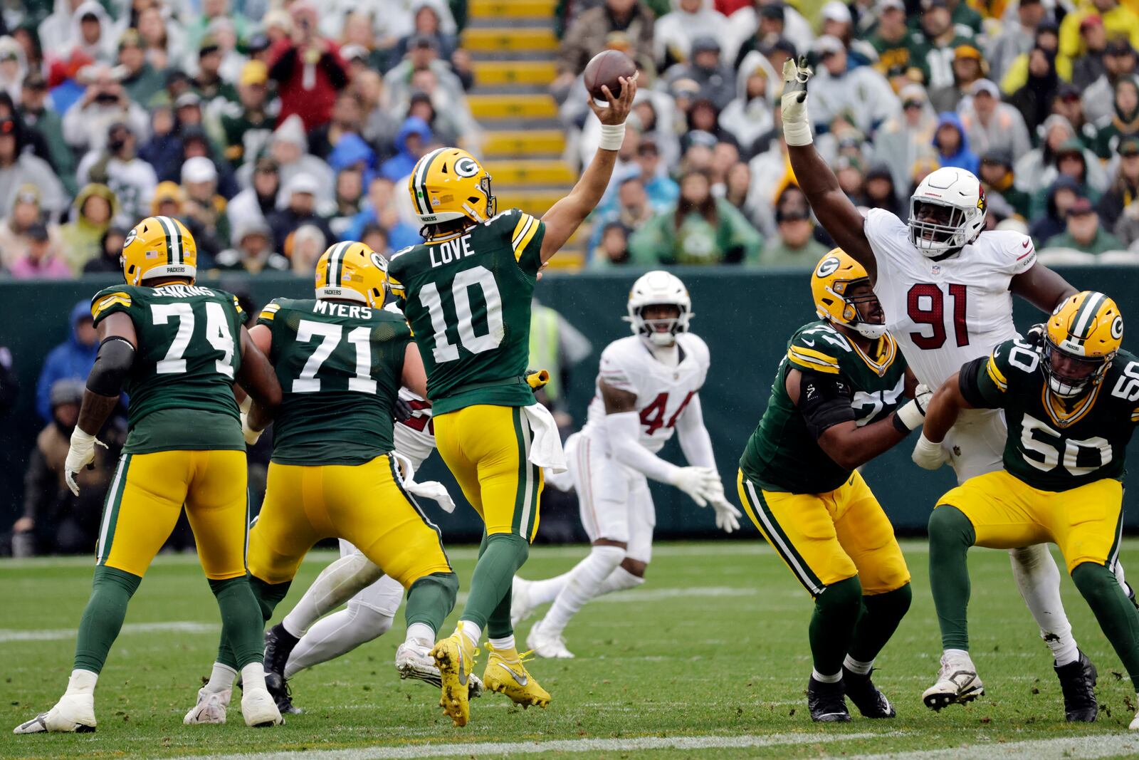 Green Bay Packers quarterback Jordan Love (10) throws over the defense of Arizona Cardinals defensive end L.J. Collier (91) during the first half of an NFL football game, Sunday, Oct. 13, 2024, in Green Bay. (AP Photo/Mike Roemer)