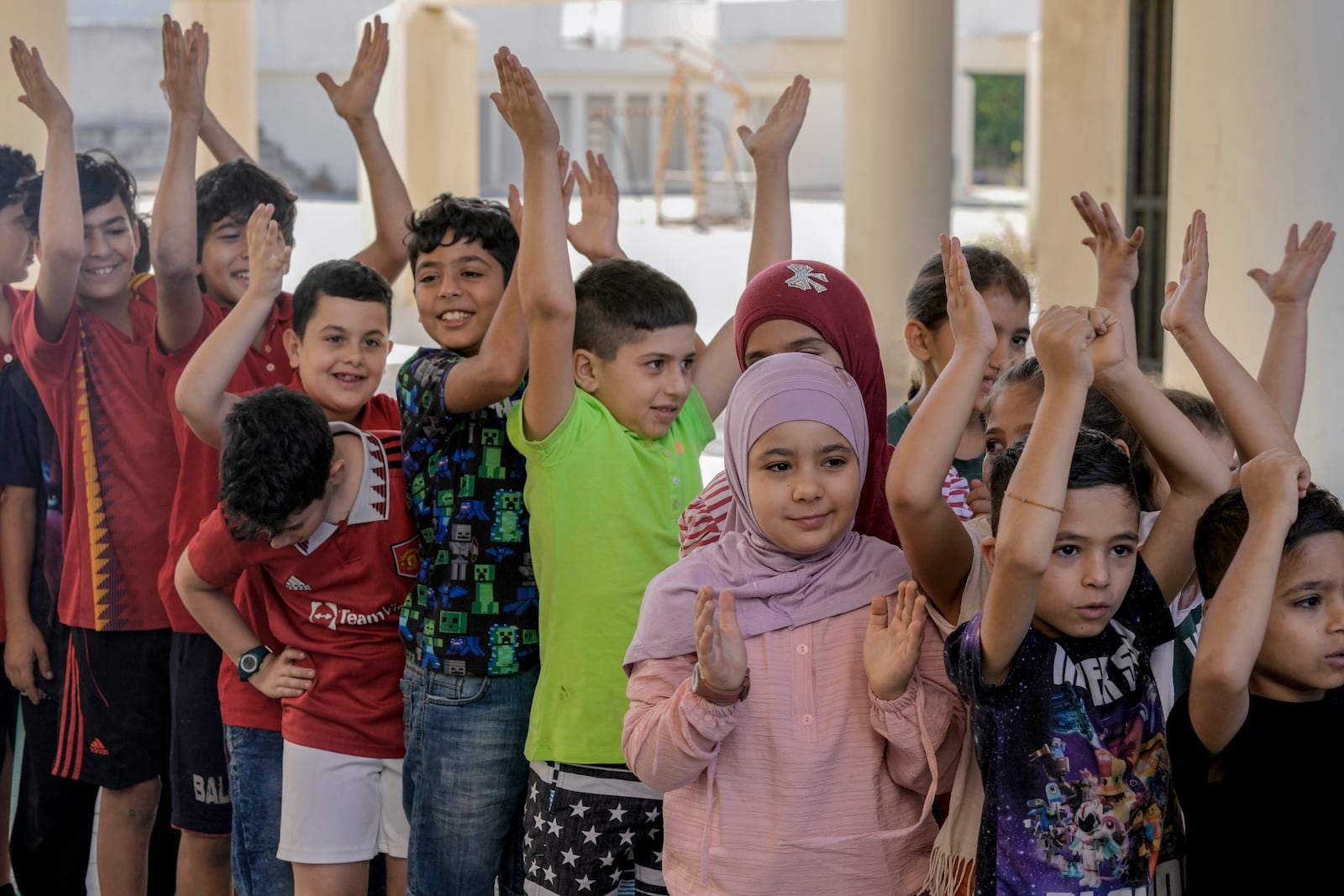 Volunteers of the Russian Cultural Center entertain displaced children at a school in Beirut, Lebanon, Thursday, Oct. 3, 2024, after fleeing the Israeli airstrikes in the south. (AP Photo/Bilal Hussein)