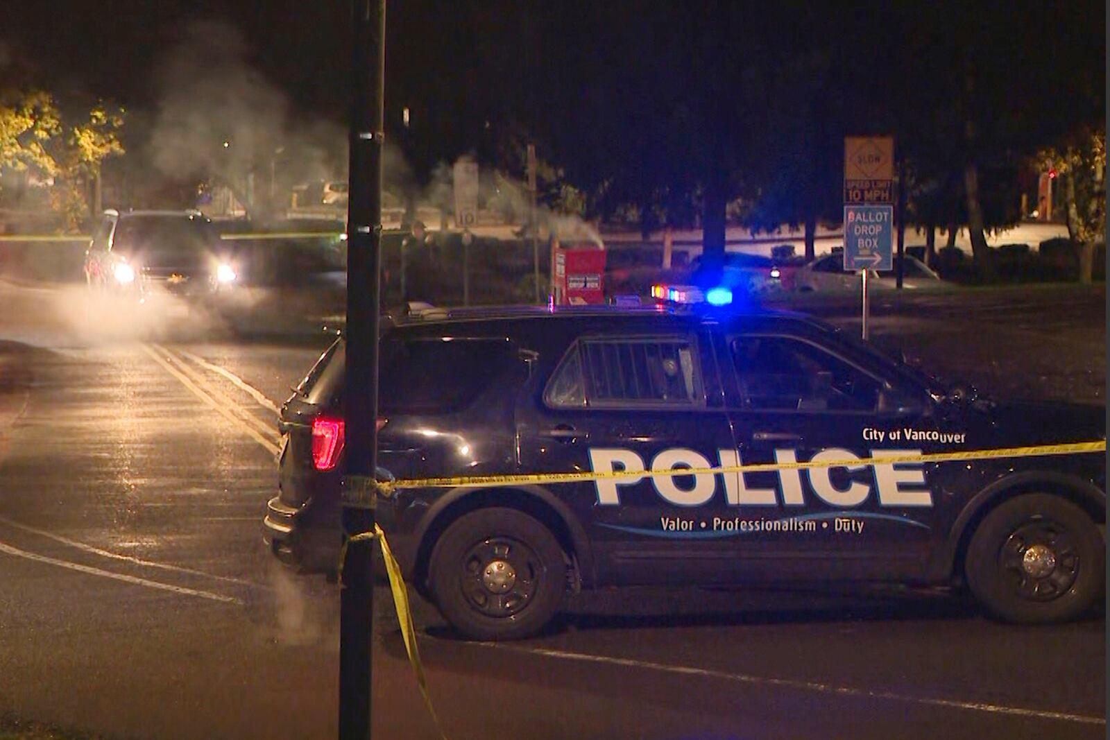 In this image made from a video provided by KGW8, authorities investigate smoke pouring out of a ballot box on Monday, Oct. 28, 2024, in Vancouver, Wash. (KGW8 via AP)