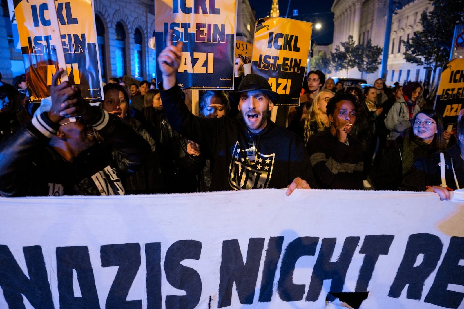 Anti right wing protesters shout slogans holding a banner that reads "Don't let Nazis rule and never let them march" near the parliament building, in Vienna, Austria, Sunday, Sept. 29, 2024, after polls closed in the country's national election. (AP Photo/Andreea Alexandru)