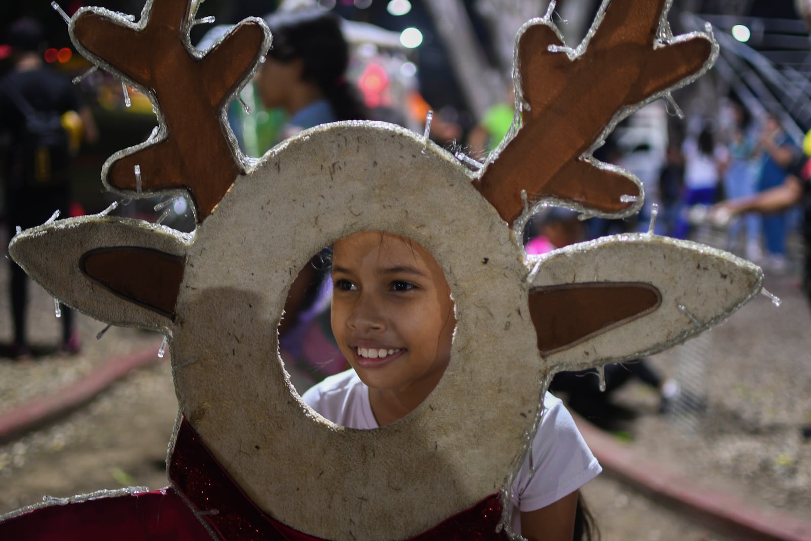 A girls poses for a photo with Christmas decorations in Valencia, Venezuela, Tuesday, Oct. 1, 2024. (AP Photo/Jacinto Oliveros)