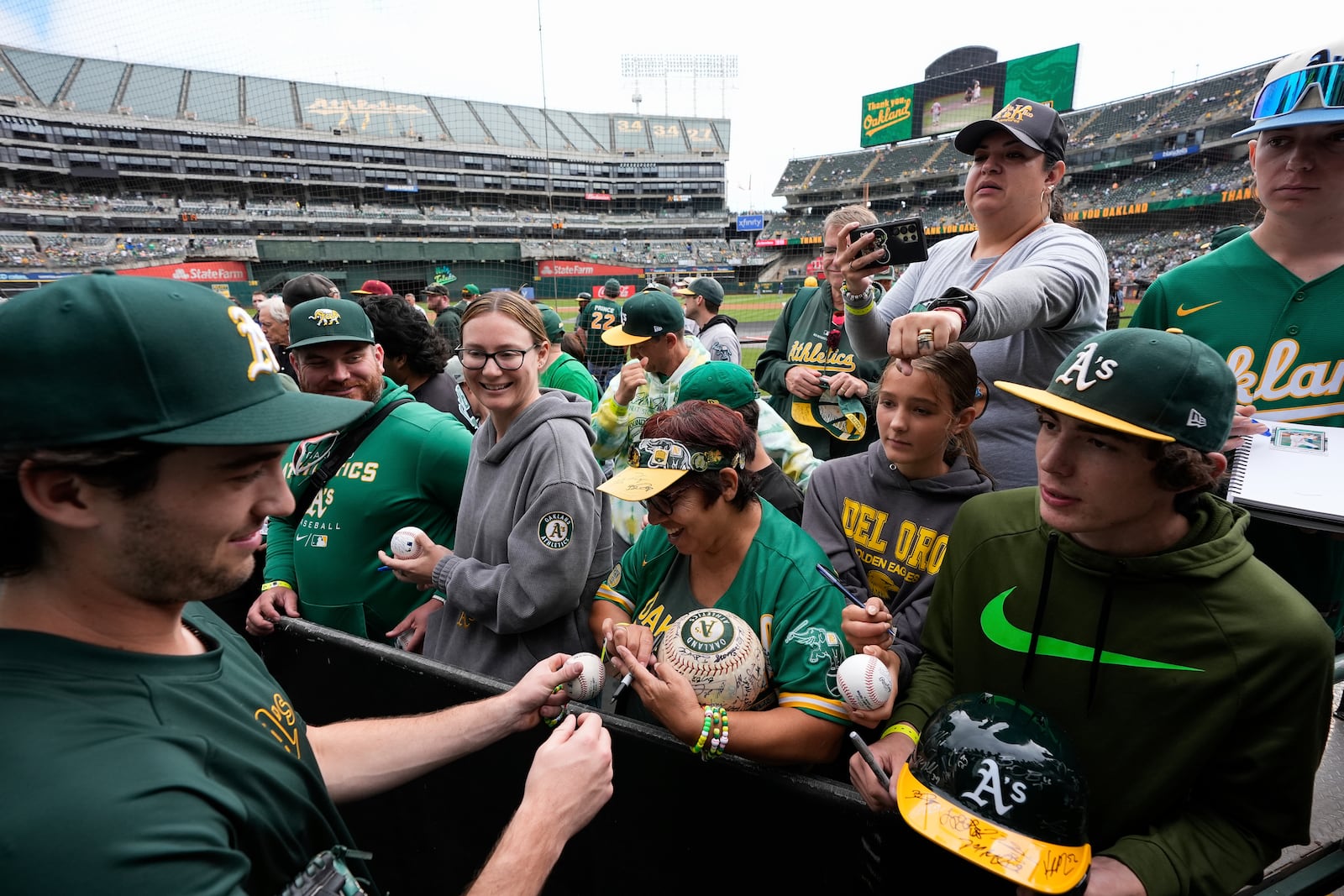 Oakland Athletics' Jacob Wilson, left, sign autographs for fans before a baseball game against the Texas Rangers, Thursday, Sept. 26, 2024, in Oakland, Calif. (AP Photo/Godofredo A. Vásquez)