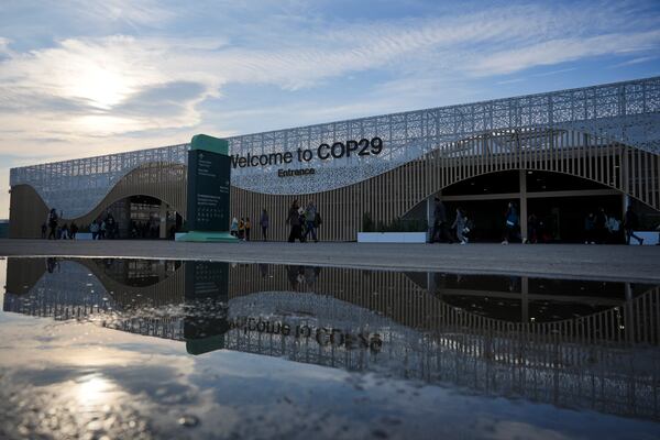 People arrive for the day outside the venue for the COP29 U.N. Climate Summit, Saturday, Nov. 16, 2024, in Baku, Azerbaijan. (AP Photo/Peter Dejong)