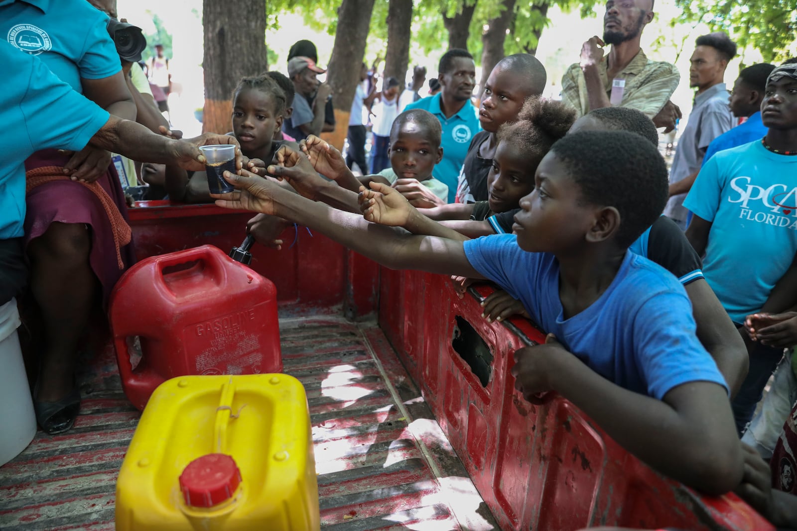 People displaced by armed attacks receive food from a nongovernmental organization in Saint-Marc, Haiti, Sunday, Oct. 6, 2024. (AP Photo/Odelyn Joseph)