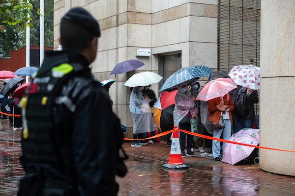 People wait to enter the West Kowloon Magistrates' Courts in Hong Kong, Wednesday, Nov. 20, 2024, ahead of Hong Kong activist publisher Jimmy Lai's national security trial. (AP Photo/Chan Long Hei)