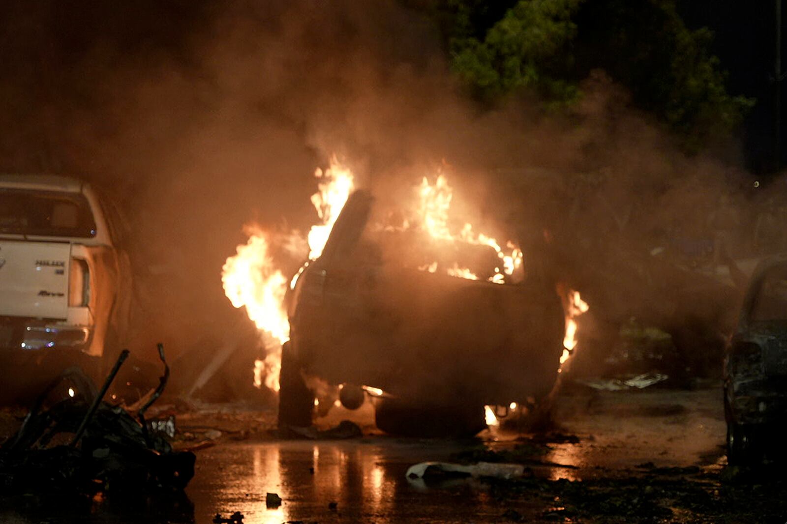 A vehicle is seen on fire at the site of an explosion that caused injures and destroyed vehicles at outside the Karachi airport, Pakistan, Sunday, Oct. 6, 2024. (AP Photo/Mohammad Farooq)