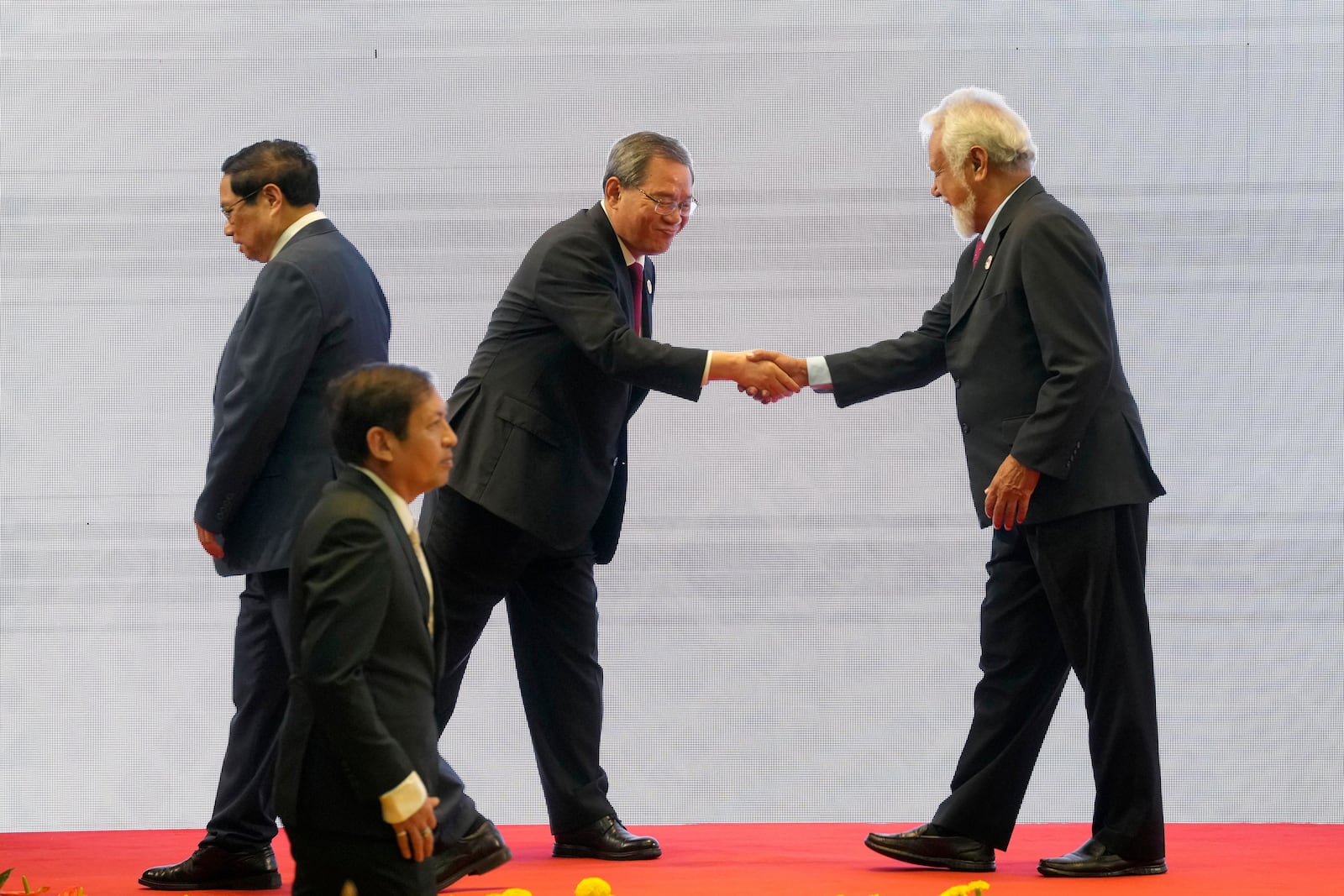 Chinese Premier Li Qiang, center, shakes hands with East Timor's Prime Minister Xanana Gusmao, right, as Vietnamese Prime Minister Pham Minh Chinh, left, and Myanmar's Foreign Ministry Permanent Secretary Aung Kyaw Moe, bottom, walk past by, during the 27th Association of Southeast Asian Nations (ASEAN)-China Summit in Vientiane, Laos, Thursday, Oct. 10, 2024. (AP Photo/Dita Alangkara)