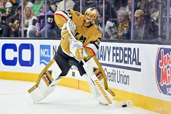 Vegas Golden Knights goaltender Adin Hill (33) handles the puck against the Minnesota Wild during the third period of Game 5 of a first-round NHL hockey playoff series Tuesday, April 29, 2025, in Las Vegas. (AP Photo/David Becker)