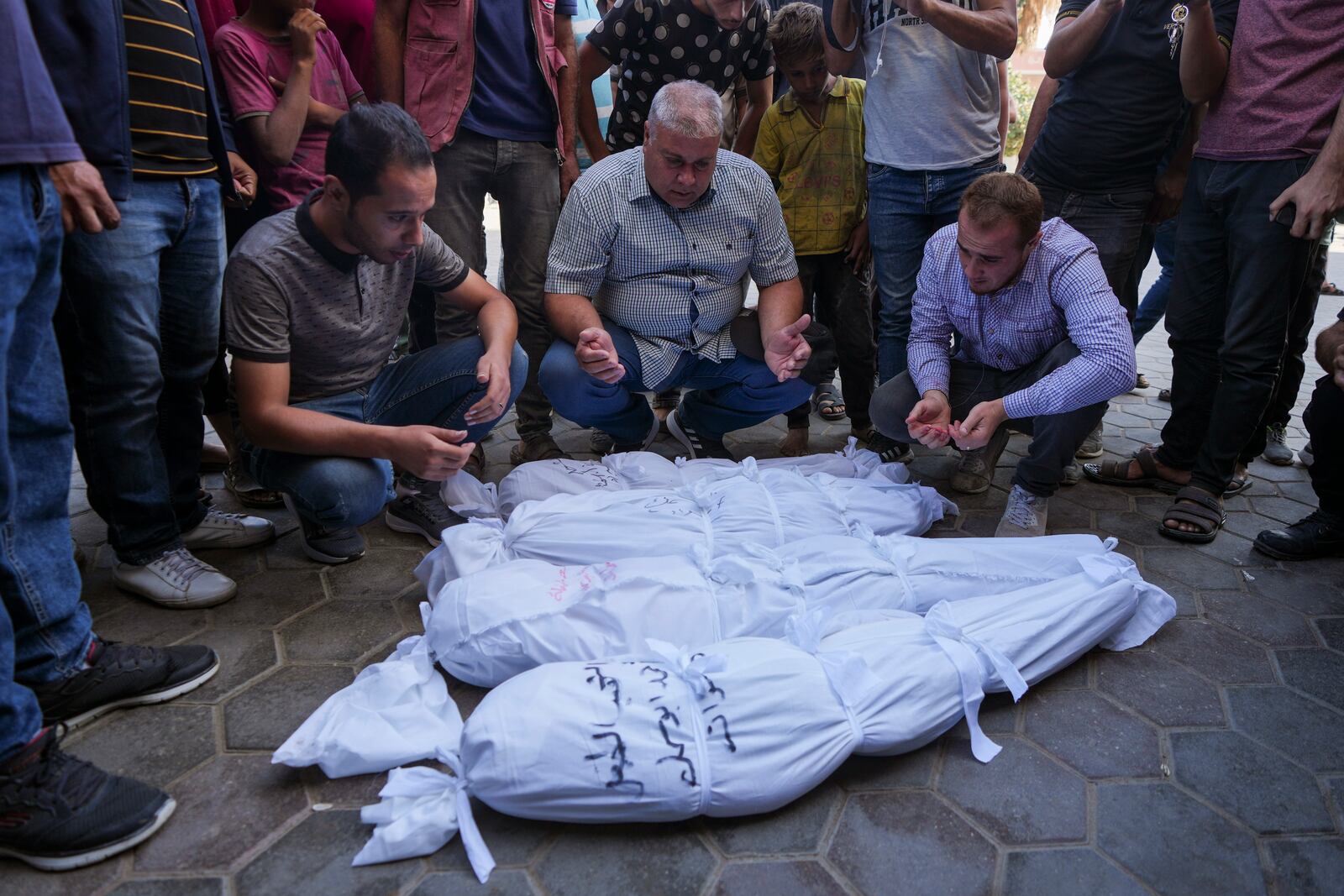 Palestinians mourn their relatives, including kids killed in the Israeli bombardment of the Gaza Strip, outside a morgue in Deir al-Balah, Gaza, Monday, Sept. 23, 2024. (AP Photo/Abdel Kareem Hana)