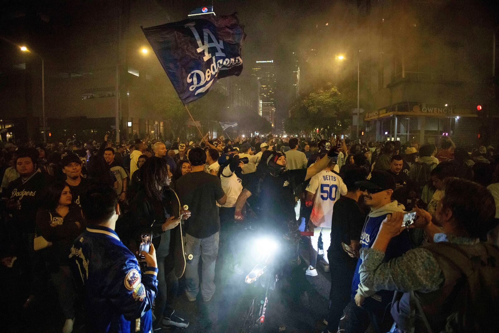 Fans celebrate on the streets after the Los Angeles Dodgers defeated the New York Yankees to win the baseball World Series Wednesday, Oct. 30, 2024, in Los Angeles. (AP Photo/Ethan Swope)