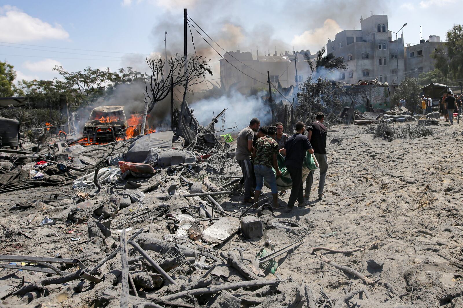 FILE - Palestinians evacuate a body from a site hit by an Israeli bombardment on Khan Younis, southern Gaza Strip, Saturday, July 13, 2024. (AP Photo/Jehad Alshrafi, File)