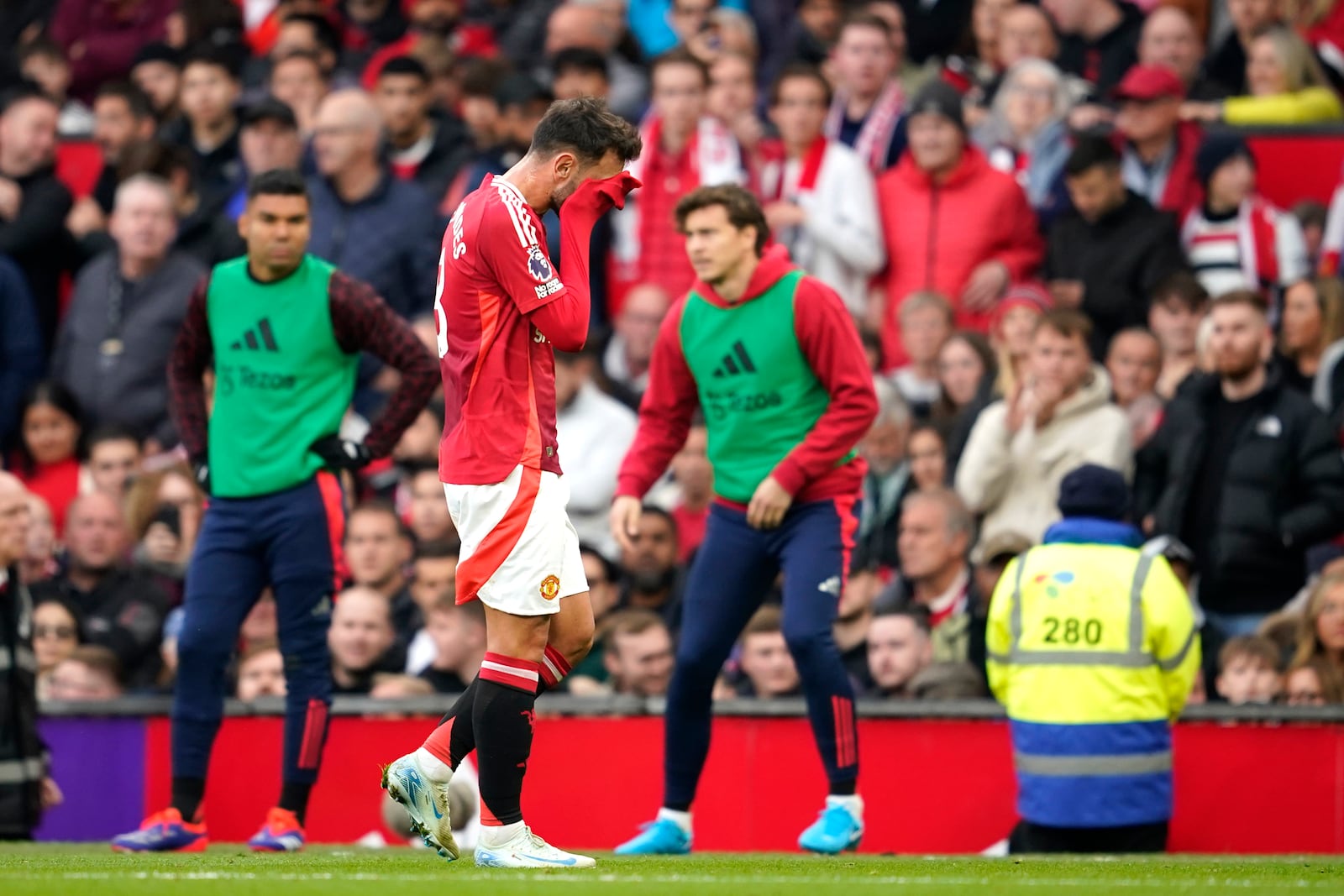 Manchester United's Bruno Fernandes walks off the pitch after receiving the red card for a foul during the English Premier League soccer match between Manchester United and Tottenham Hotspur at Old Trafford stadium in Manchester, England, Sunday, Sept. 29, 2024. (AP Photo/Dave Thompson)