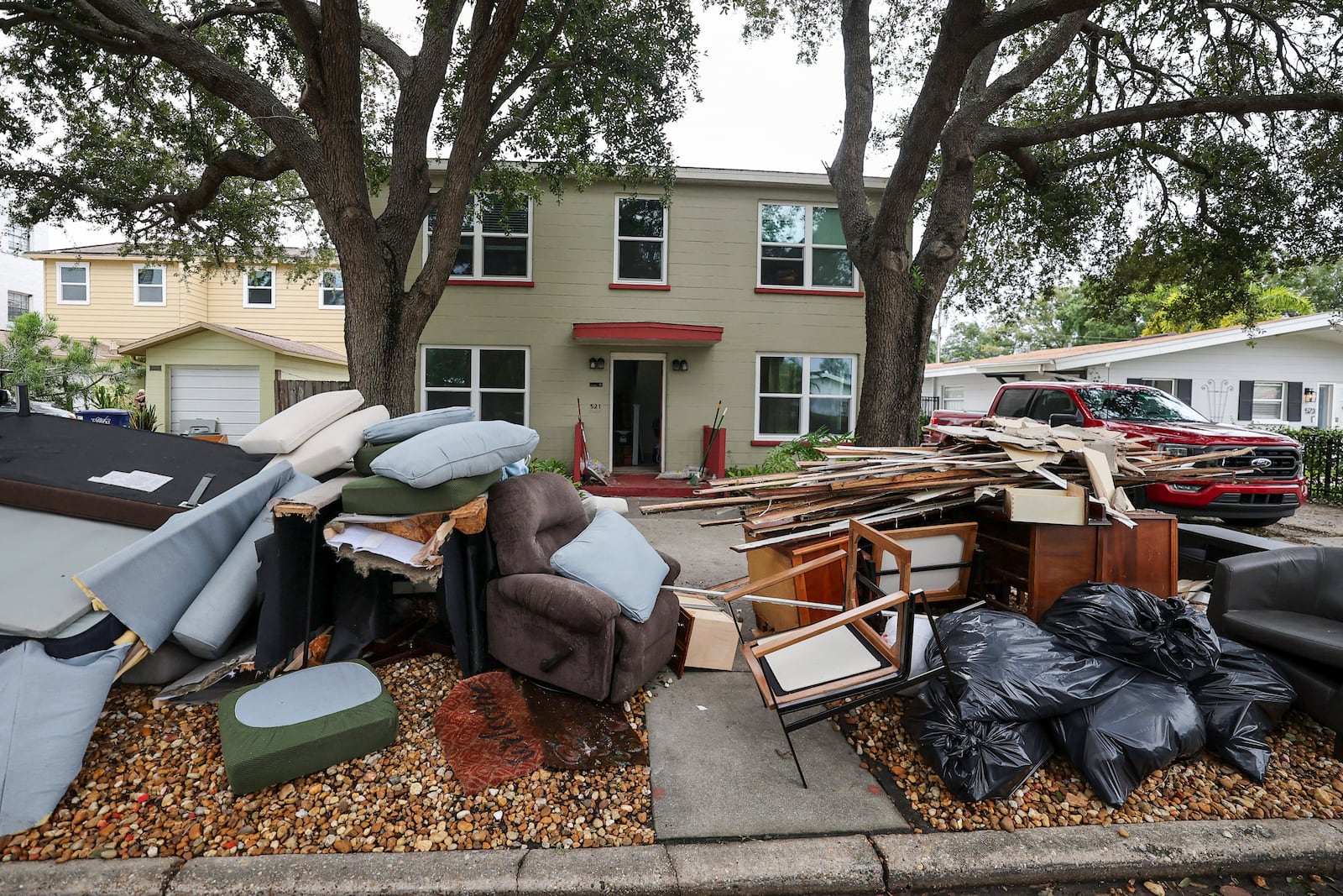 Contents of homes are piled on the side of the road after flooding from Hurricane Helene on Davis Island Saturday, Sept. 28, 2024, in Tampa, Fla. (AP Photo/Mike Carlson)