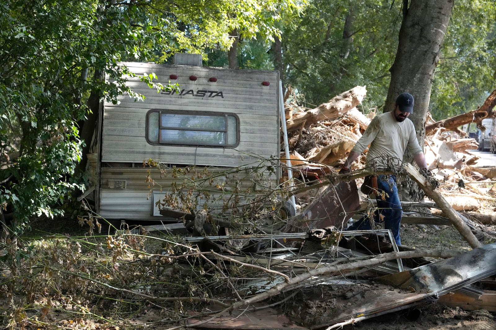 A person clears debris left in the aftermath of Hurricane Helene Saturday, Oct. 5, 2024, in Del Rio, Tenn. (AP Photo/Jeff Roberson)