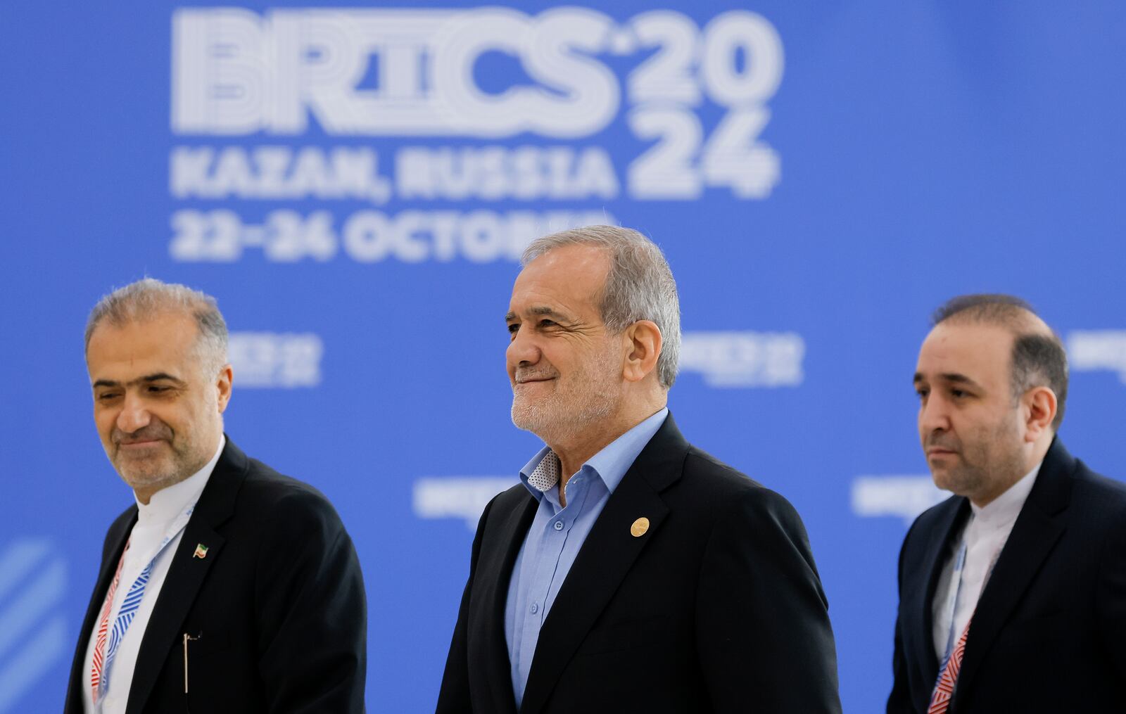 Iranian President Masoud Pezeshkian, center, accompanied by Iranian Ambassador to Russia Kazem Jalali, left, arrives at BRICS Summit in Kazan, Russia, Wednesday, Oct. 23, 2024. (Maxim Shemetov/Pool Photo via AP)