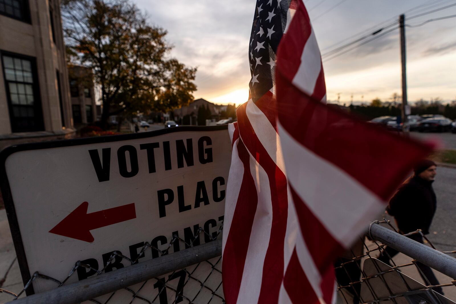 An American flag flies in the wind as a voter leaves a polling site after casting a ballot on Election Day, Tuesday, Nov. 5, 2024, in Dearborn, Mich. (AP Photo/David Goldman)