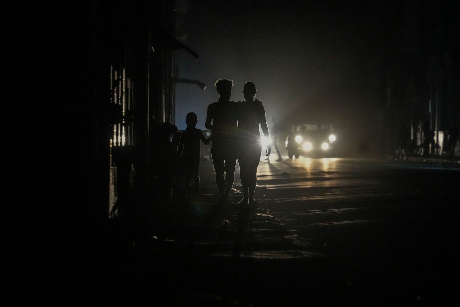 Residents walk on a street during a blackout following the failure of a major power plant in Havana, Cuba, Sunday, Oct. 20, 2024. (AP Photo/Ramon Espinosa)