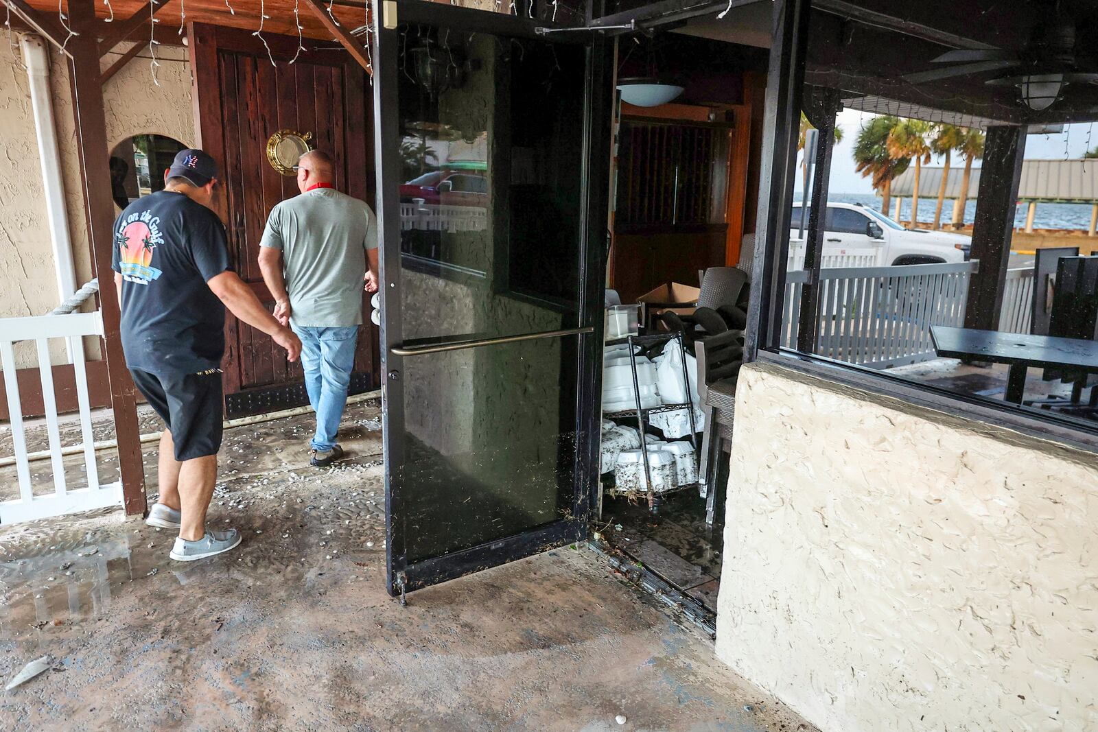 Staff of the Inn On The Gulf clean up after their restaurant flooded with surge from Hurricane Helene Friday, Sept. 27, 2024, in Hudson, Fla. (AP Photo/Mike Carlson)