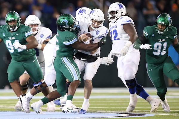 Tulane Green Wave linebacker Sam Howard (15) sacks Memphis Tigers quarterback Seth Henigan (9) first half action in New Orleans, Thursday, Nov. 28, 2024. (AP Photo/Peter Forest)