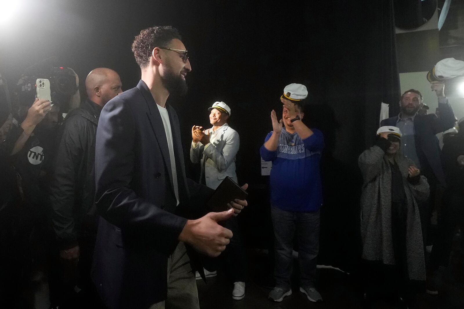 Dallas Mavericks guard Klay Thompson, foreground left, is greeted by Golden State Warriors employees and media as he arrives before an Emirates NBA Cup basketball game between the Warriors and the Mavericks in San Francisco, Tuesday, Nov. 12, 2024. (AP Photo/Jeff Chiu)