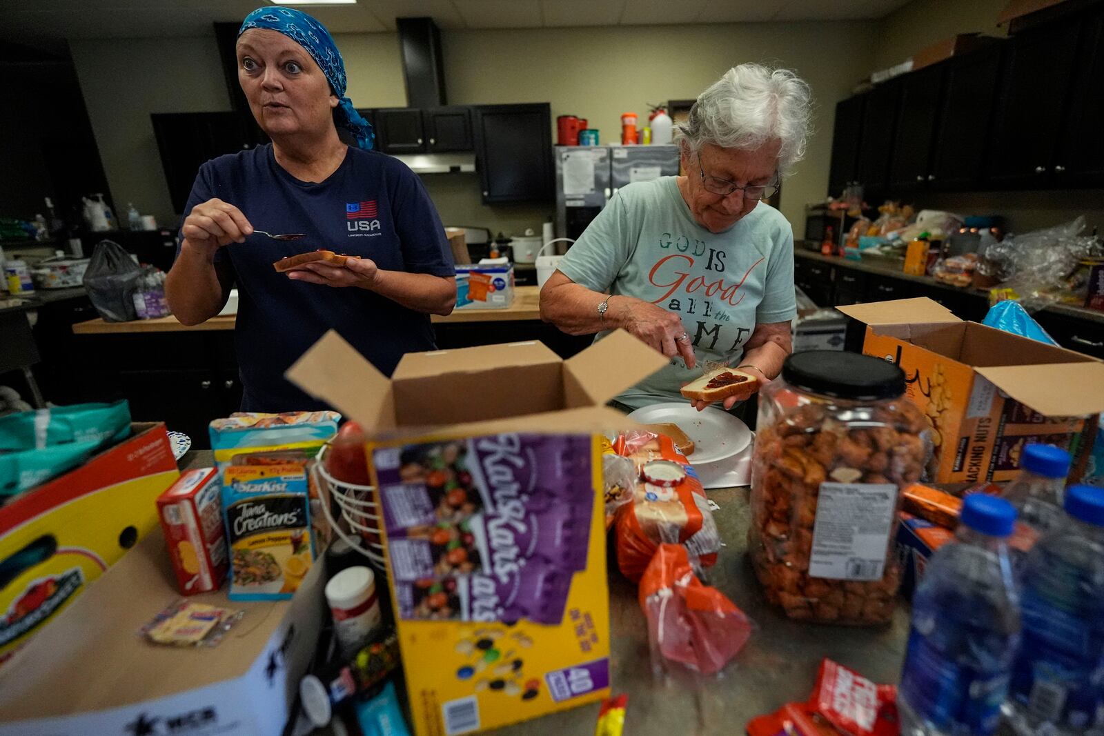 Volunteers prepare meals for firefighters and others at the volunteer fire station in the aftermath of Hurricane Helene, Thursday, Oct. 3, 2024, in Pensacola, N.C. (AP Photo/Mike Stewart)