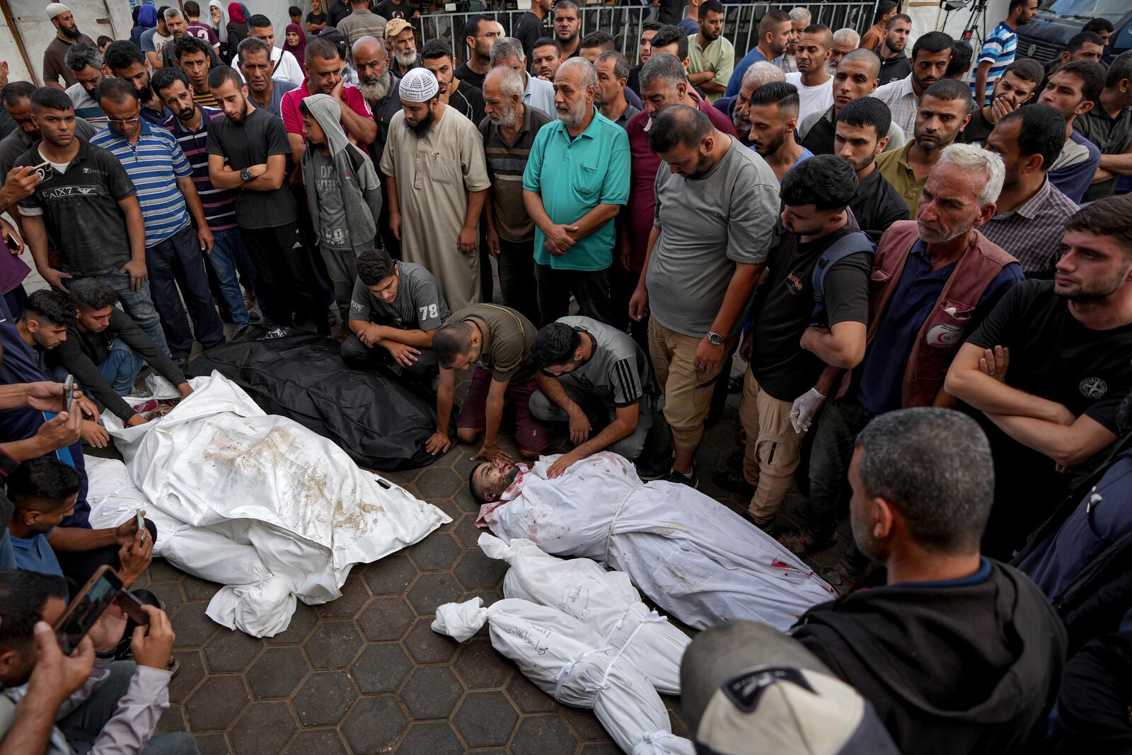 Palestinians mourn their relatives killed in the Israeli bombardment of the Gaza Strip at a hospital in Deir al-Balah, Tuesday, Oct. 8, 2024. (AP Photo/Abdel Kareem Hana)