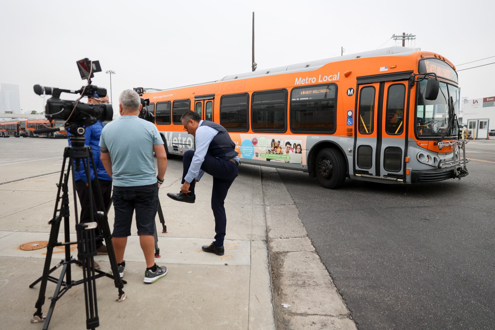 A bus passes by waiting news media in front of a Los Angeles MTA bus depot near the site where overnight a bus was hijacked by an armed subject with passengers on board Wednesday, Sept. 25, 2024, in Los Angeles. One person was fatally shot before police apprehended the suspect. (AP Photo/Ryan Sun)