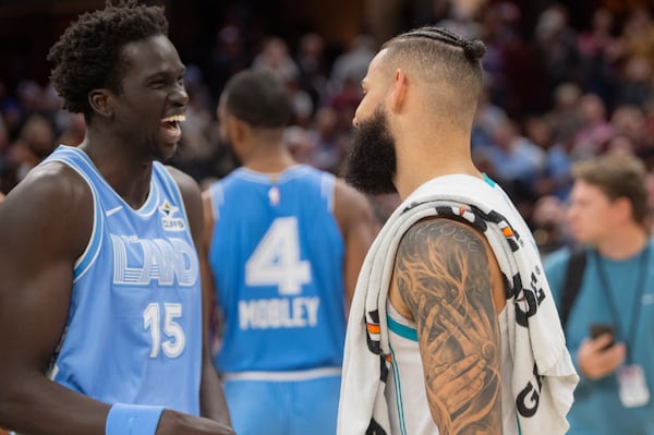 Cleveland Cavaliers' JT Thor (15) laughs with Charlotte Hornets' Cody Martin, right, at the end of an NBA basketball game in Cleveland, Sunday, Nov 17, 2024. (AP Photo/Phil Long)